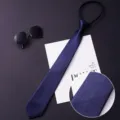 Men's zipper tie detail view showing the deep blue silky textured fabric and fine weave. - 017
