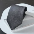 Close-up detail of a premium dark grey textured business necktie for formal suits. - Zipper Style / Gray Starry Sky