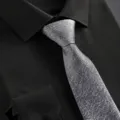 Detailed view of a silver shimmering tie paired with a classic black dress shirt for business formal wear. - Gray Starry Sky Zipper Tie
