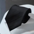 Detail view of black formal business tie with textured stripes. Premium men's accessory. - Zipper Style / Black Dark Pattern