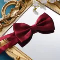Burgunderroter Seidenfliege Detailaufnahme auf prunkvollem Vintage Goldspiegel für Festmode. - Glatte Burgundarote Fliege