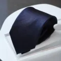 Detailed close-up shot of a dark blue striped necktie showing exquisite woven texture. - Zipper Style / Navy Stripe
