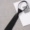 Close-up detail of a black zipper tie, solid textured fabric, convenient lazy tie design. - Style 016