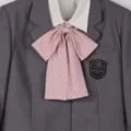 Vue détaillée du blazer d'uniforme scolaire gris avec chemise blanche et nœud papillon. - Noeuds papillon à pois à tige longue - rose