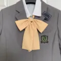 Detailed view of cute JK uniform yellow polka dot bow tie with grey blazer and white shirt. - Yellow Polka Dot Bow Tie
