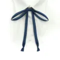 Vue détaillée d'un nœud cravate JK en satin bleu marine avec une texture lisse et soignée. - Cordons de cou bleu marine