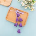 Close-up detail of purple PU leather tassel keychain charm with custom name tag for bags. - Purple Style (B442-4)