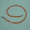 Detailed shot of amber acrylic eyeglass chain link, stylish eyewear strap accessory. - Bright Coffee