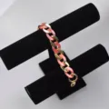 Detailed view of pink acrylic and gold metal chunky chain strap accessory for bags and phones. - Ruby Red Mixed Gold