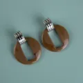 Close-up detail of large brown acrylic geometric dangle earrings with silver top. - Exaggerated Geometric Hoop / Chocolate