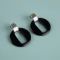 Detail shot of oversized acrylic geometric drop earrings in black and silver tone design. - Exaggerated Geometric Hoop / Solid Black