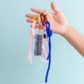 Λεπτομέρεια από πολύχρωμα DIY υφαντά λουράκια μπρελόκ και κρεμαστά τσάντας με μεταλλικά κουμπώματα. - Στυλ B384-3