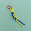 Close-up detail of the woven yellow and blue paracord bag charm with a red metal carabiner. - Red