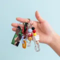 Close-up detail of a colorful DIY charm keychain featuring mixed beads, chains, and camo strap. - B382-12