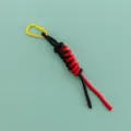 Detailed view of handmade black red paracord bag charm with yellow mini metal carabiner. - Yellow