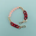 Detailed view of short phone charm chain featuring pink flower beads and red resin links. - Pink Floral Pattern Chain