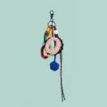Detail view of a multi-element DIY bag charm with resin links, leather ring, and blue knot. - Letter O Style (B402-O)