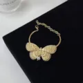 Detail van de vintage gouden vlinder choker halsketting met elegante parelhanger voor dames. - Armband (1502) / Goud