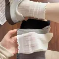 Nahaufnahme von atmungsaktiven Mesh-Socken mit zartem Rüschenbesatz in verschiedenen Farben. - Einheitsgröße / Weiß
