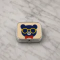 Gros plan détaillé du motif d'ours en perles avec lunettes de soleil sur boîte en métal. - Style Ours Bleu (4)