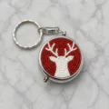 Detail view of a Christmas beaded metal pillbox keychain with a festive red and white reindeer design. - Red Background White Reindeer Style