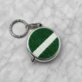 Gros plan du porte-clés boîte à pilules en métal perlé vert et blanc et ses détails précis. - Style Rayé Vert et Blanc (2)