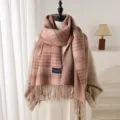 Detailed view of the cozy plaid winter scarf featuring soft fringe and elegant pink tones. - Pink