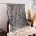 Close-up of the elegant paisley pattern and fringe detail on the cozy gray winter shawl scarf. - Gray