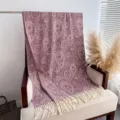 Detailed view of autumn winter paisley tassel scarf soft cashmere feel shawl draped on chair. - Red