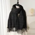 Vue détaillée de l'écharpe à carreaux noirs et blancs effet cachemire avec franges pour l'hiver. - Noir