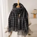 Nahaufnahme eines klassischen schwarz-weißen Schals mit Fransen und weicher, warmer Textur. - Schwarz