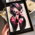 Detalle de pañuelo cuadrado de seda con estampado floral, diseño elegante negro y rosa, suave. - FG56-2