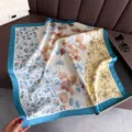 Detalle de pañuelo cuadrado de seda con estampado floral, borde azul elegante accesorio mujer. - FG48-2