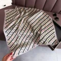 Detailed view of the luxury silk square scarf featuring elegant horse and belt stripe patterns. - FG52-3 Light Pink