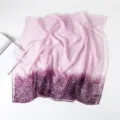 Vista detallada de la bufanda de gasa morada con degradado suave y estampado floral fino. - Púrpura