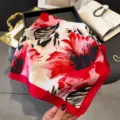 Detail view of the vibrant red and pink floral print silk square scarf, soft texture and elegant design. - Red
