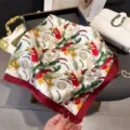 Tropical plant print silk scarf detail, vibrant colors with red border, elegant accessory. - Red