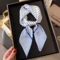 Detail view of stylish white silk square scarf with classic blue polka dot design for women. - White