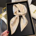Detailed view of a luxurious beige satin silk square scarf with elegant vintage printed scroll patterns. - 70*70cm / Khaki