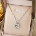 Vista dettagliata di una splendida collana con ciondolo a doppio cuore con pietre e rosa. - Collana Cuore in Strass Lucido (Catena a Labbra) / Argento
