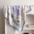 Detail shot of a 70cm silk-like floral square scarf featuring elegant blue lotus print and blue border. - Blue Edge