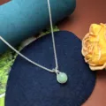 Detailed view of silver sparkly clavicle chain with a green jade lucky bag pendant. - Green Lucky Bag