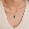 Primo piano della collana con ciondolo a zucca verde con catena dorata e pietre scintillanti. - Catena a forma di labbra / Oro-Verde