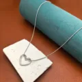 Dettaglio in primo piano della collana con ciondolo a cuore in argento, gioiello trendy. - Stile Cuore Traforato / Argento-Collana Cuore Traforata
