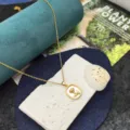 Primo piano di una delicata collana dorata con un ciondolo floreale in madreperla. - Collana Rosa in Madreperla / Oro