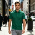 Vue détaillée d'un polo vert élégant porté par un mannequin marchant dans une rue de la ville. - Vert clair