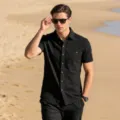 Detailansicht eines lässigen schwarzen Leinen-Mischgewebe-Hemds an einem Strand getragen. - S / Oberteile / Schwarz