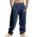 Close-up detail of men's blue casual linen trousers featuring comfortable drawstring waist and flag patch. - S / Bottoms / Navy Blue