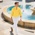 Outdoor lifestyle shot showing the casual long-sleeve shirt and linen pants detail. - Yellow and White