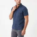 Close-up detail of a dark blue short sleeve shirt with dual chest pockets and button closure. - Navy Blue